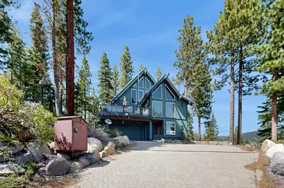 a blue house with a balcony on a driveway at Lake View Escape in Incline Village