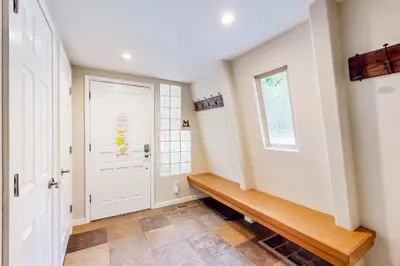 a hallway with a white door and a wooden bench at Boothill Adventures in Incline Village