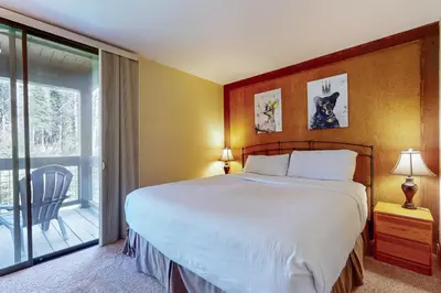 a bedroom with a large bed and a balcony at Aspen Grove Condo in Truckee