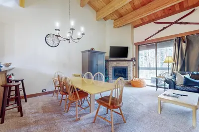 a dining room with a table and chairs and a fireplace at Aspen Grove Condo in Truckee