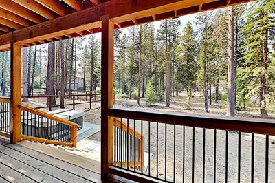 a wooden porch with a view of a forest at Saponi Escape in South Lake Tahoe