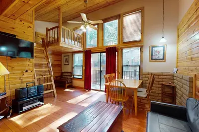 a living room with a staircase in a log cabin at Ski Run Village 11 in South Lake Tahoe