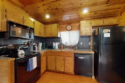 a kitchen with wooden cabinets and a black refrigerator at Ski Run Village 11 in South Lake Tahoe