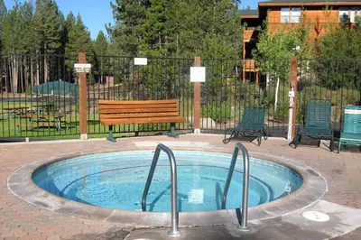 a hot tub with a wooden bench and a bench at Wolfgang Dreams in Truckee