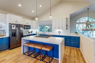 a kitchen with blue cabinets and a large island with bar stools at Koyukon Escape in South Lake Tahoe