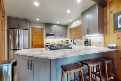 a kitchen with a island with bar stools in it at Cozy Tahoe Donner Retreat in Truckee