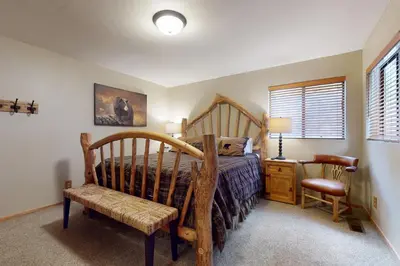 a bedroom with a wooden bed and a chair at Cozy Tahoe Donner Retreat in Truckee