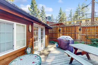 a wooden deck with a picnic table and a bench at Pioneer Palace in South Lake Tahoe