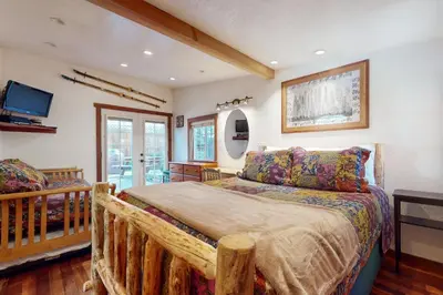 a bedroom with a wooden bed and a tv at Pioneer Palace in South Lake Tahoe