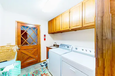 a laundry room with a washing machine and a wooden door at St Bernard Oasis in Truckee