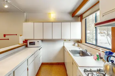 a kitchen with white cabinets and a sink and a window at Aspen Grove Escape in Truckee