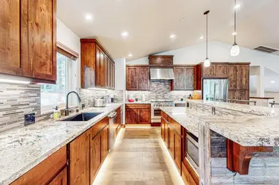 a kitchen with wooden cabinets and marble counter tops at Prospector Palace in South Lake Tahoe