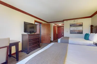 a hotel room with two beds and a flat screen tv at Resort at Squaw Creek's 806 & 808 in Olympic Valley
