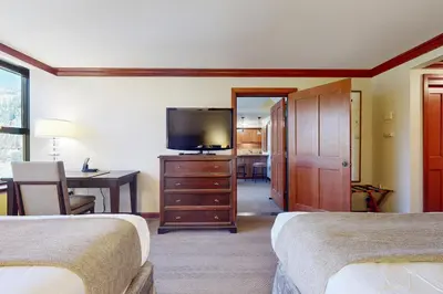 a hotel room with two beds and a flat screen tv at Resort at Squaw Creek's 806 & 808 in Olympic Valley