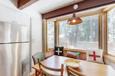 a dining room with a table and a refrigerator at Alpine Haven in Tahoe City