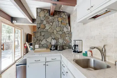 a kitchen with a sink and a stone wall at Alpine Haven in Tahoe City