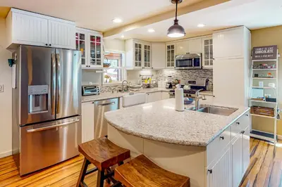 a kitchen with white cabinets and a stainless steel refrigerator at Golden Adventures in Kings Beach