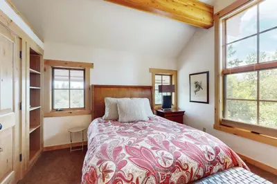 a bedroom with a bed and two windows at Mount Olympia Oasis in South Lake Tahoe