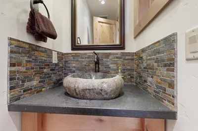 a bathroom with a stone sink and a mirror at Mount Olympia Oasis in South Lake Tahoe