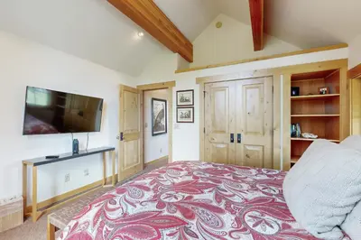 a bedroom with a large bed and a flat screen tv at Mount Olympia Oasis in South Lake Tahoe