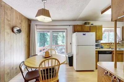 a kitchen with a table and a white refrigerator at Pineland Escape in Tahoe City