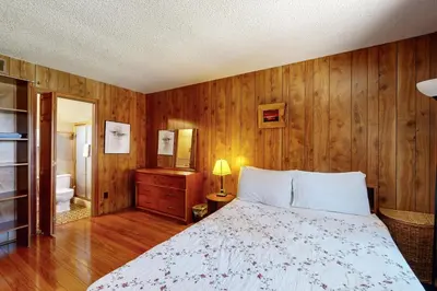 a bedroom with a bed and a wooden wall at Pineland Escape in Tahoe City