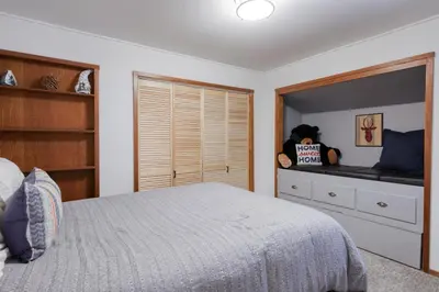 a bedroom with a bed and a person sitting on a shelf at Dodawah Oasis in Carnelian Bay