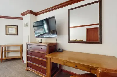 a room with a wooden dresser and a mirror at Resort at Squaw Creek's 317 & 319 in Olympic Valley