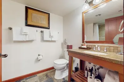 a bathroom with a toilet and a sink and a mirror at Resort at Squaw Creek's 317 & 319 in Olympic Valley