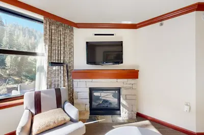 a living room with a fireplace and a tv at Resort at Squaw Creek's 521 in Olympic Valley