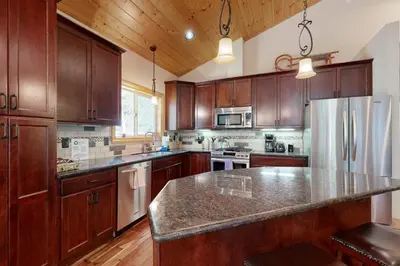 a kitchen with wooden cabinets and a stainless steel refrigerator at Serenity at Northwoods in Truckee