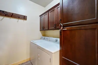 a laundry room with a washer and a wooden door at Serenity at Northwoods in Truckee
