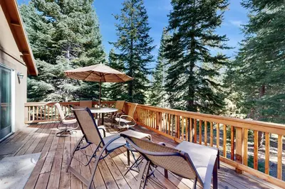 a deck with a table and chairs and an umbrella at Zermatt Getaway in Truckee