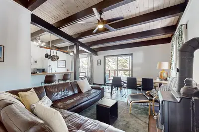 a living room with a leather couch and a ceiling fan at Scott Peak Lodges Condo in Alpine Meadows