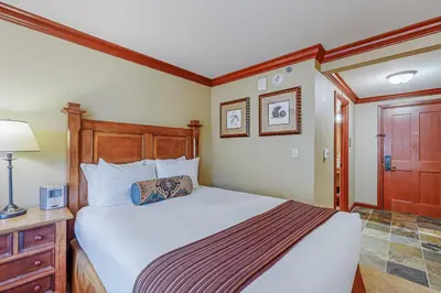 a bedroom with a large bed and a wooden headboard at Resort at Squaw Creek's 605 & 607 in Olympic Valley