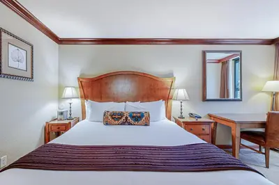 a bedroom with a bed with a wooden headboard and a desk at Resort at Squaw Creek's 605 & 607 in Olympic Valley
