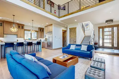 a living room with blue couches and a kitchen at Henness Haven in Truckee