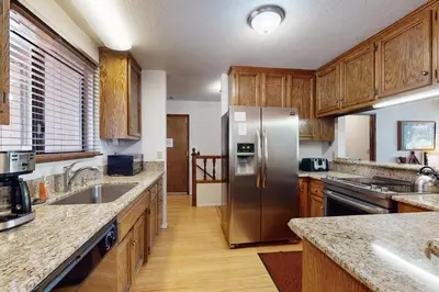 a kitchen with wooden cabinets and a stainless steel refrigerator at High Meadows Retreat in South Lake Tahoe