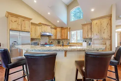 a kitchen with wooden cabinets and a island with bar stools at Wagon Wood Retreat in South Lake Tahoe