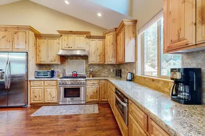 a kitchen with wooden cabinets and stainless steel appliances at Wagon Wood Retreat in South Lake Tahoe