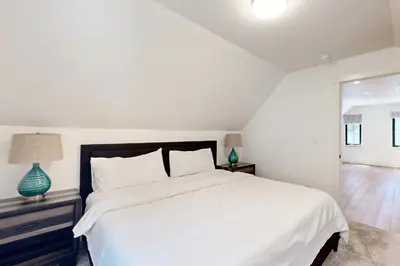a white bedroom with a large bed and a window at North Lake Adventure in Carnelian Bay