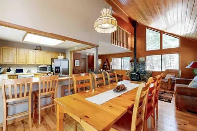 a dining room and kitchen with a wooden table and chairs at Schussing Escape in Truckee