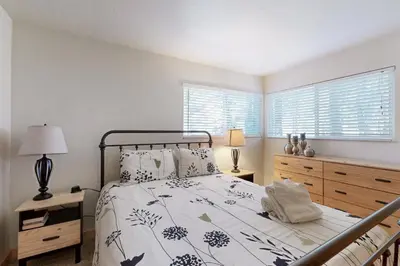 a bedroom with a bed and two lamps and a window at Miztec Manor in South Lake Tahoe