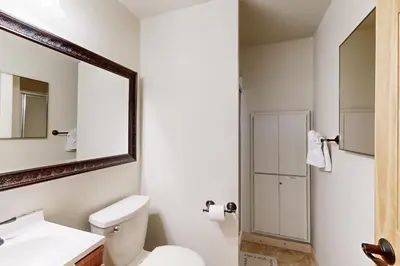 a bathroom with a white toilet and a mirror at Miztec Manor in South Lake Tahoe
