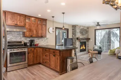 a kitchen with wooden cabinets and a fireplace at Lakeview Manor in South Lake Tahoe