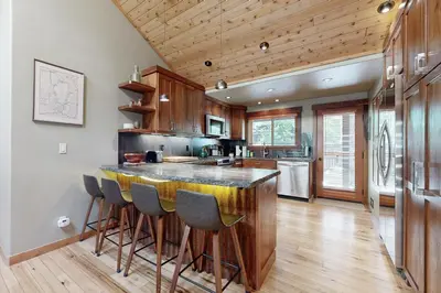 a kitchen with a bar with stools at Westshore Oasis in Tahoma
