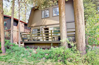 a house with a balcony in the woods at Sky Meadows Charmer in South Lake Tahoe