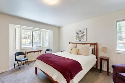 a bedroom with a large bed and two windows at Schussing Paradise in Truckee