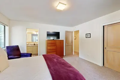 a bedroom with a bed and a chair and a television at Schussing Paradise in Truckee