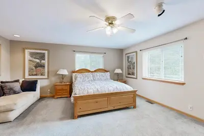 a bedroom with a bed and a couch and a ceiling fan at Oregon Oasis in South Lake Tahoe